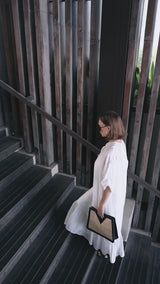Model wearing black sunglasses, white dress, and holding Jenn Lee Careyes Tote
