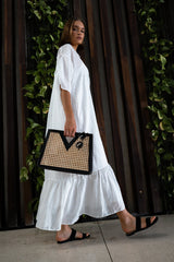 Model wearing white dress and holding Jenn Lee Careyes Tote