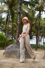 Model wearing straw hat, Jenn Lee Beige Linen top and Jenn Lee Beige Linen Drawstring pants