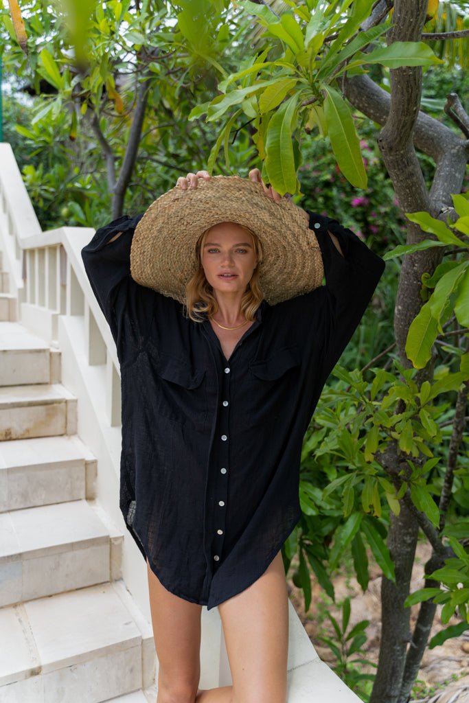 Model wearing straw hat and Jenn Lee Black Oversized Travel Shirt