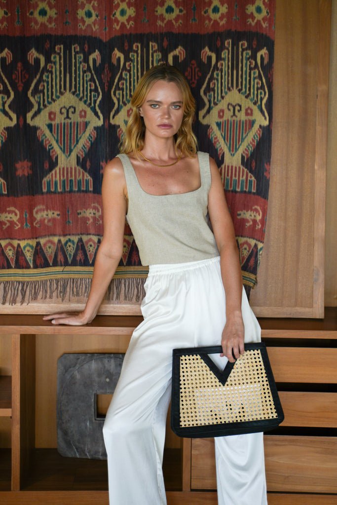 Model wearing Jenn Lee Beige Linen Shell top and Jenn Lee Luxe White pants, holding Jenn Lee Careyes tote