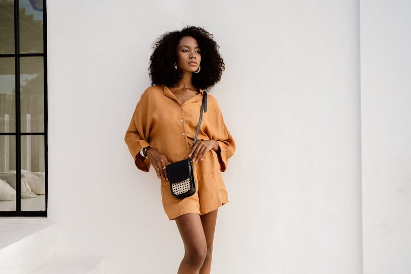 Model wearing Jenn Lee Jamu Short Sleeve Shirt, Jenn Lee Jamu Shorts, and Jenn Lee Milos Micro Bag