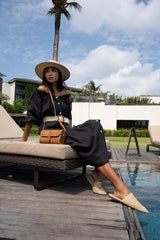 Model wearing straw hat, black dress, and Jenn Lee Bidadari Crossbody