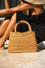 Model sitting next to Jenn Lee Santorini Bag